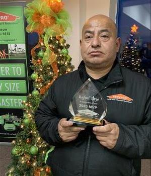 picture of male employee Rafael in front of a SERVPRO banner