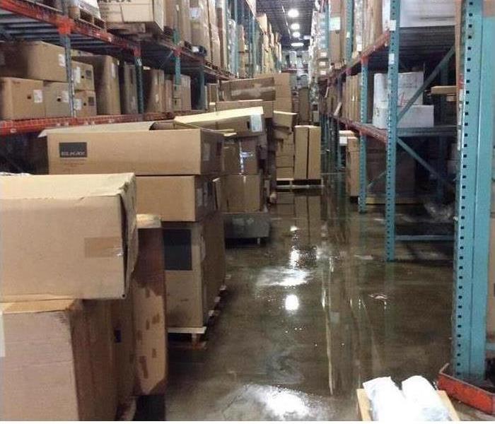 Pictlure of a warehouse with boxes and water on the floor