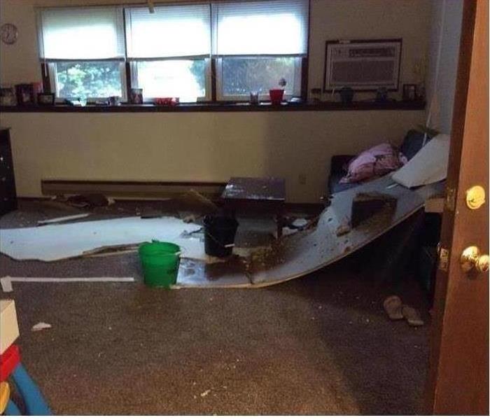 picture of a room that the drop ceiling fell to the floor due to the water damage in the apartment above
