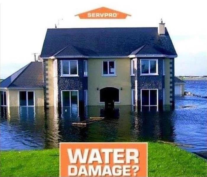 picture of a home surrounded by water with the SERVPRO logo at the top