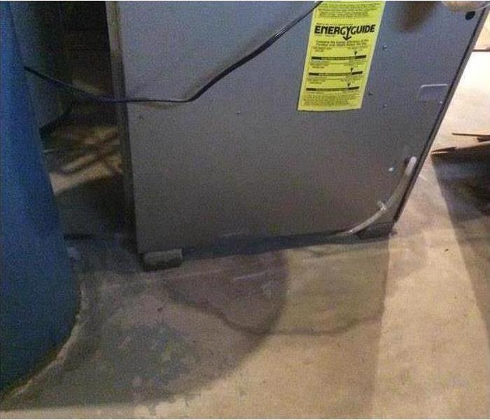 picture of a puddle of water on a basement floor in the utility room