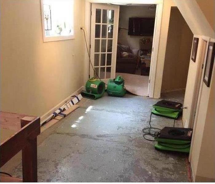 picture of a floor with carpet removed and dehumidifiers placed around 