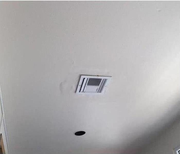 picture of a ceiling vent with water damage around it 