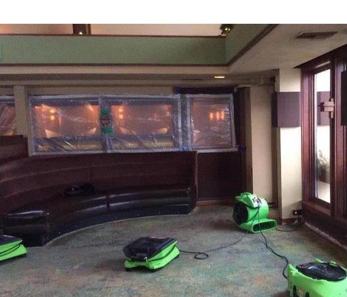 picture of a restaurant dining room with servpro fans placed to dry the area